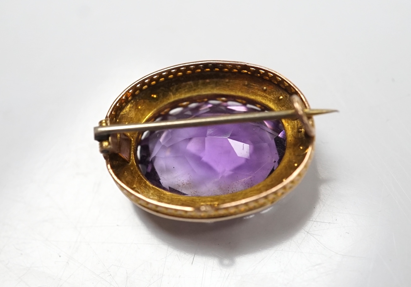 A mid 20th century 9ct and single stone oval cut amethyst set pendant brooch, with seed pearl border, 24mm, gross weight 4.8 grams. Condition - fair to good